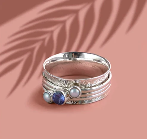 Chunky spinner ring with blue gemstones lays flat